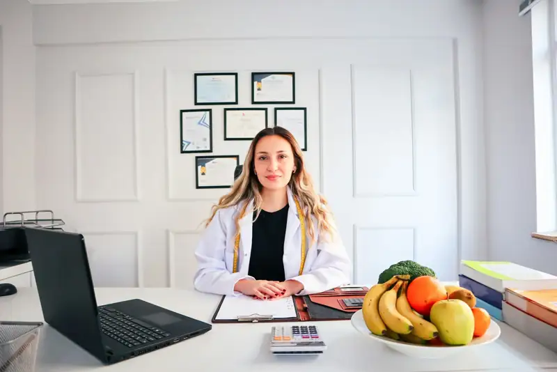 Nutricionista trabalhando no notebook em seu consultório